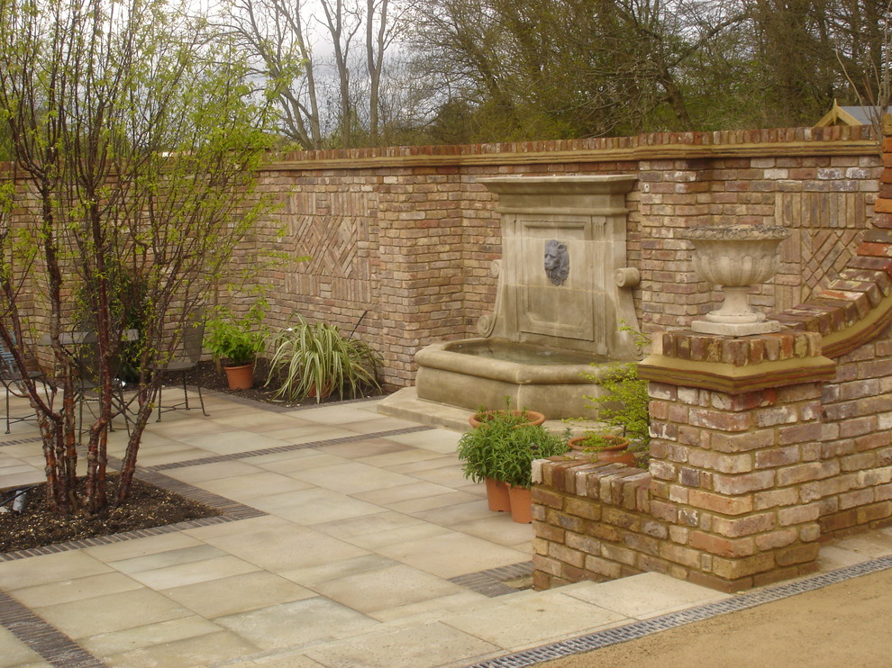 Inspiration for a large traditional courtyard formal full sun garden for summer in Other with a garden path and natural stone paving.