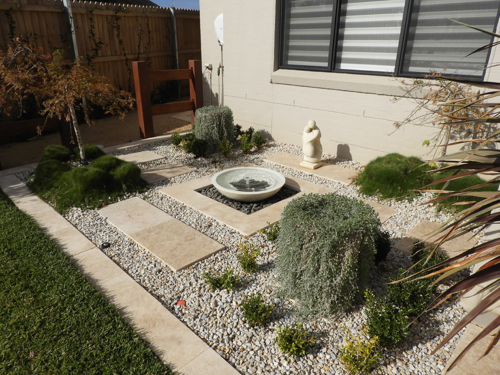 Foto de jardín minimalista de tamaño medio en primavera en patio trasero con jardín francés, exposición parcial al sol y adoquines de ladrillo