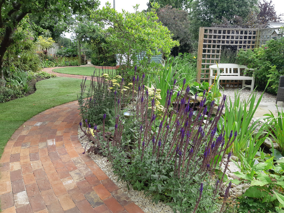 Foto de jardín campestre de tamaño medio en patio trasero con parterre de flores