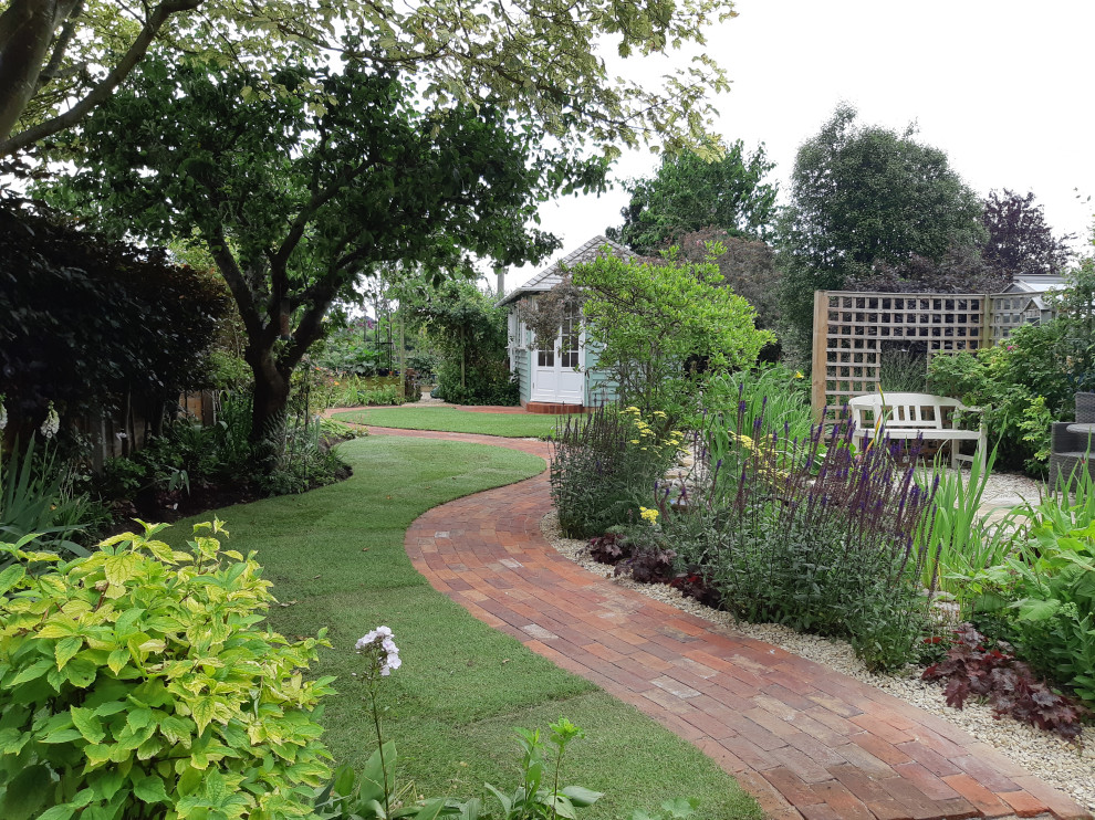 Aménagement d'un jardin arrière campagne de taille moyenne avec un chemin et des pavés en brique.