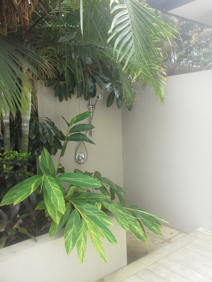 Foto di un grande giardino tropicale esposto a mezz'ombra nel cortile laterale con un focolare e pedane
