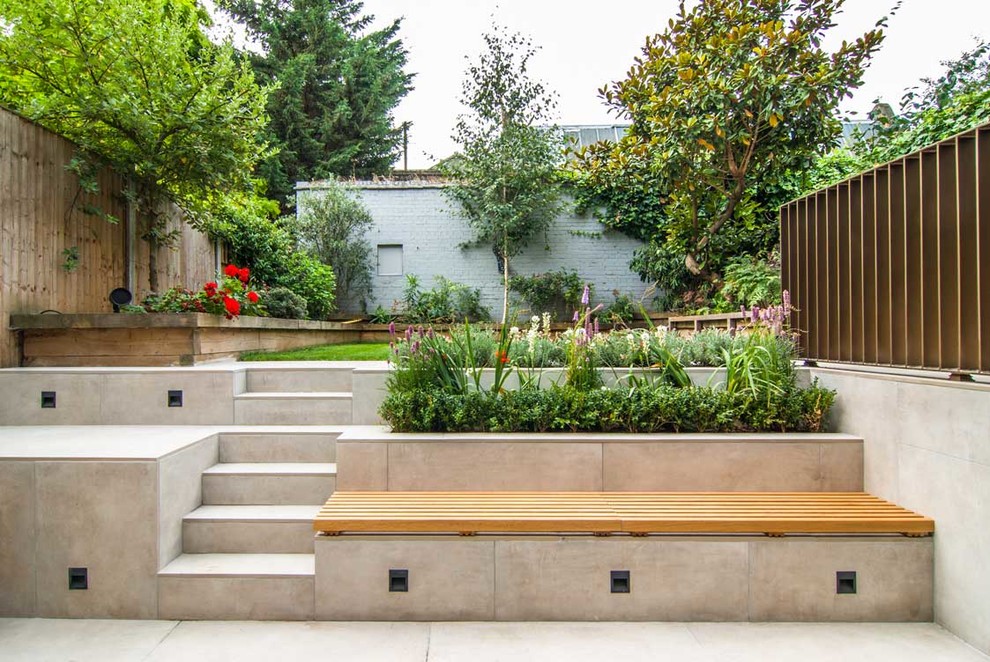 Medium sized modern back formal full sun garden in London with a garden path and concrete paving.