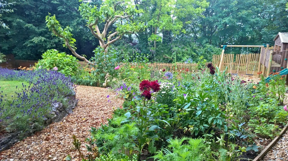 Foto de jardín campestre grande en ladera con brasero y adoquines de piedra natural