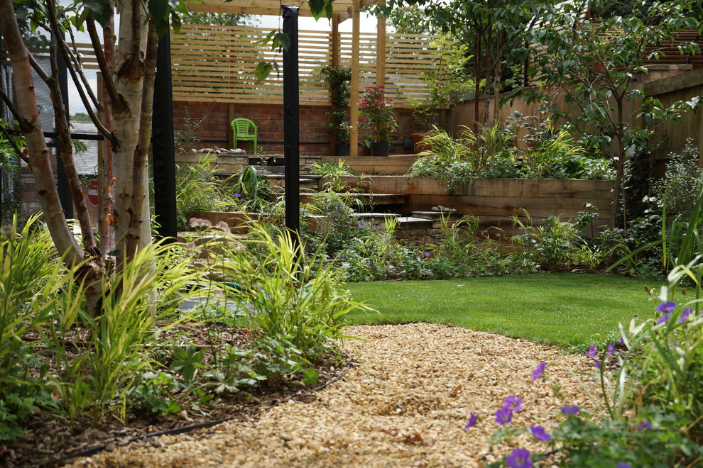 Photo of a large traditional back formal full sun garden for summer in West Midlands with a pond and decking.