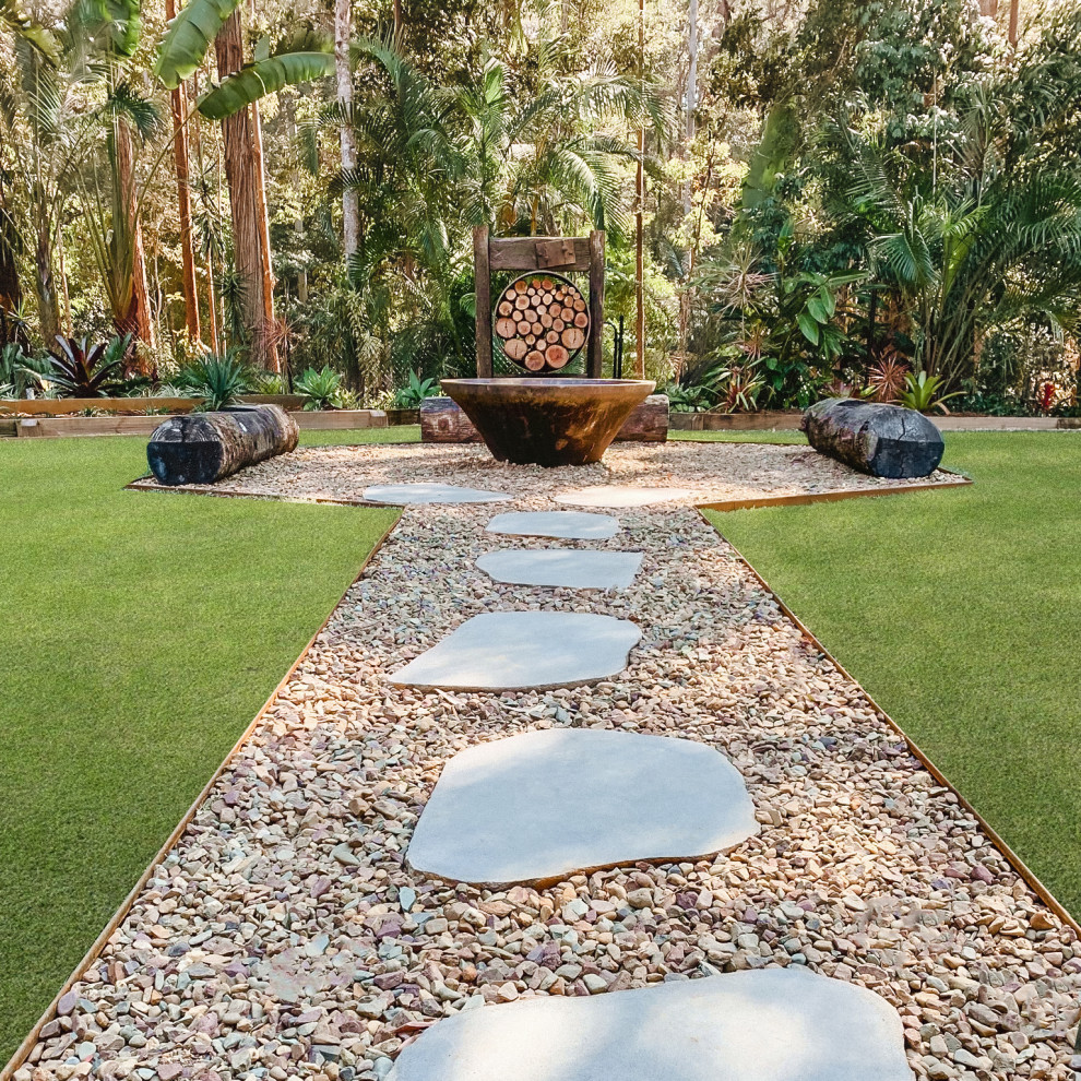Esempio di un giardino formale tropicale esposto a mezz'ombra di medie dimensioni e davanti casa in inverno con un focolare e pavimentazioni in pietra naturale