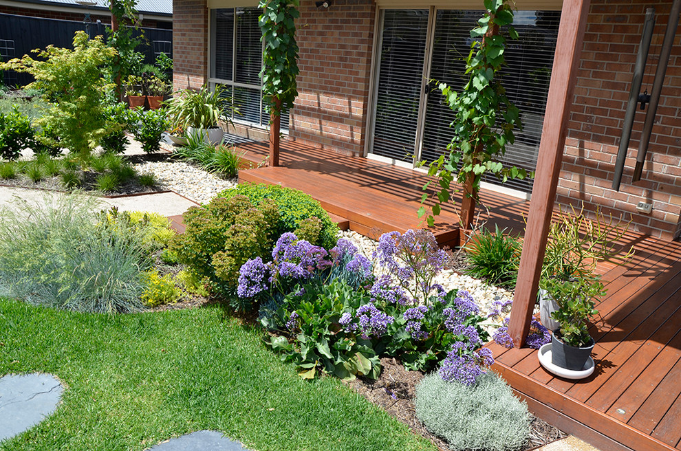 На фото: большой солнечный, весенний засухоустойчивый сад на заднем дворе в современном стиле с хорошей освещенностью и покрытием из гравия с
