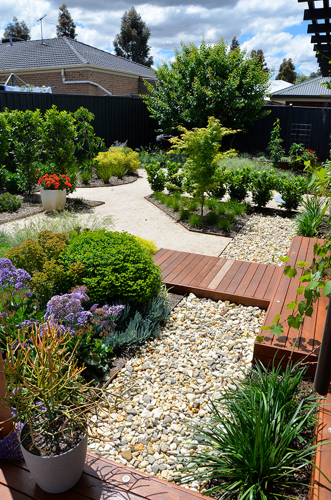 Foto de jardín de secano contemporáneo grande en primavera en patio trasero con exposición total al sol y gravilla