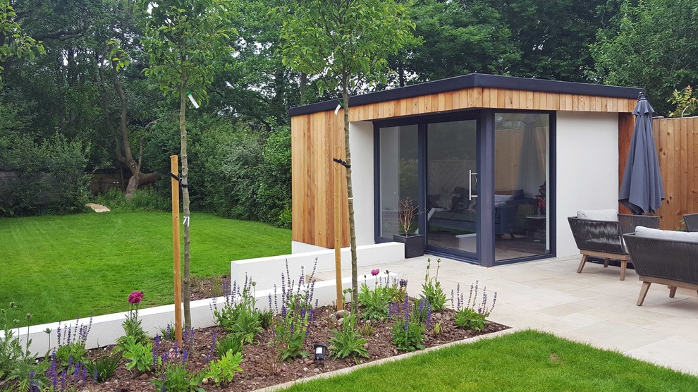This is an example of a contemporary full sun garden in West Midlands with concrete paving.