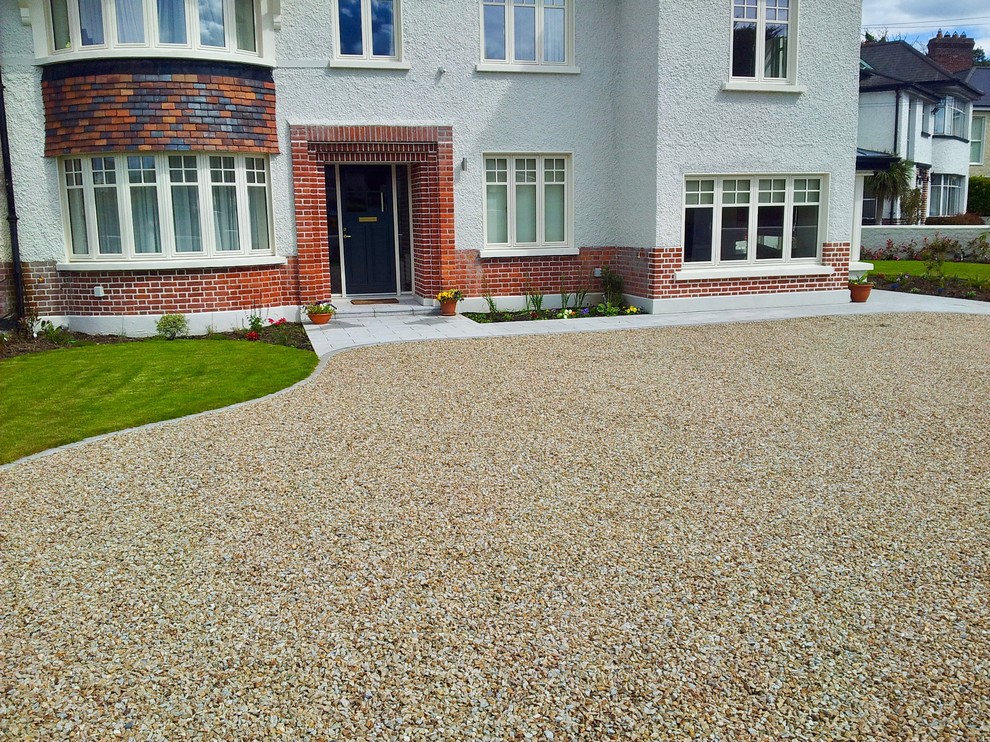 Photo of a large contemporary front driveway full sun garden for summer in Dublin with a garden path, natural stone paving and a stone fence.