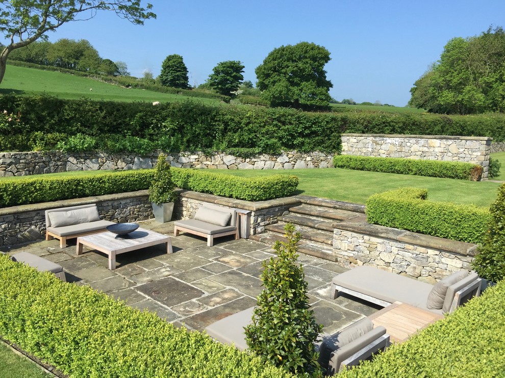 Geometrische, Geräumige Klassische Gartenmauer im Sommer, hinter dem Haus mit direkter Sonneneinstrahlung und Natursteinplatten in West Midlands