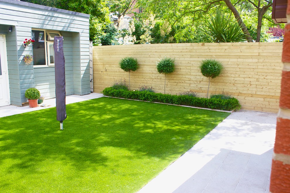 Idées déco pour un petit jardin arrière contemporain l'été avec une exposition partiellement ombragée, des pavés en pierre naturelle et une clôture en bois.