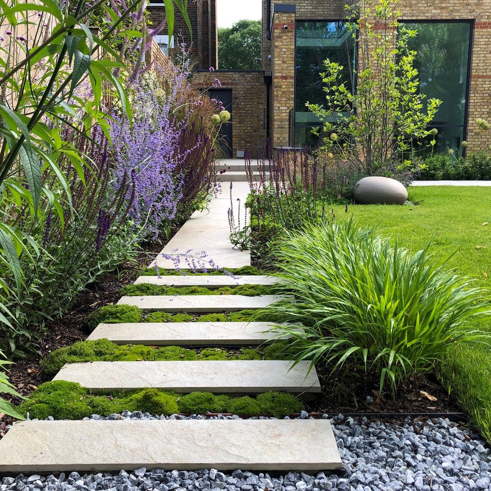 Idee per un giardino formale design esposto a mezz'ombra di medie dimensioni e dietro casa in estate con un muro di contenimento e pavimentazioni in pietra naturale