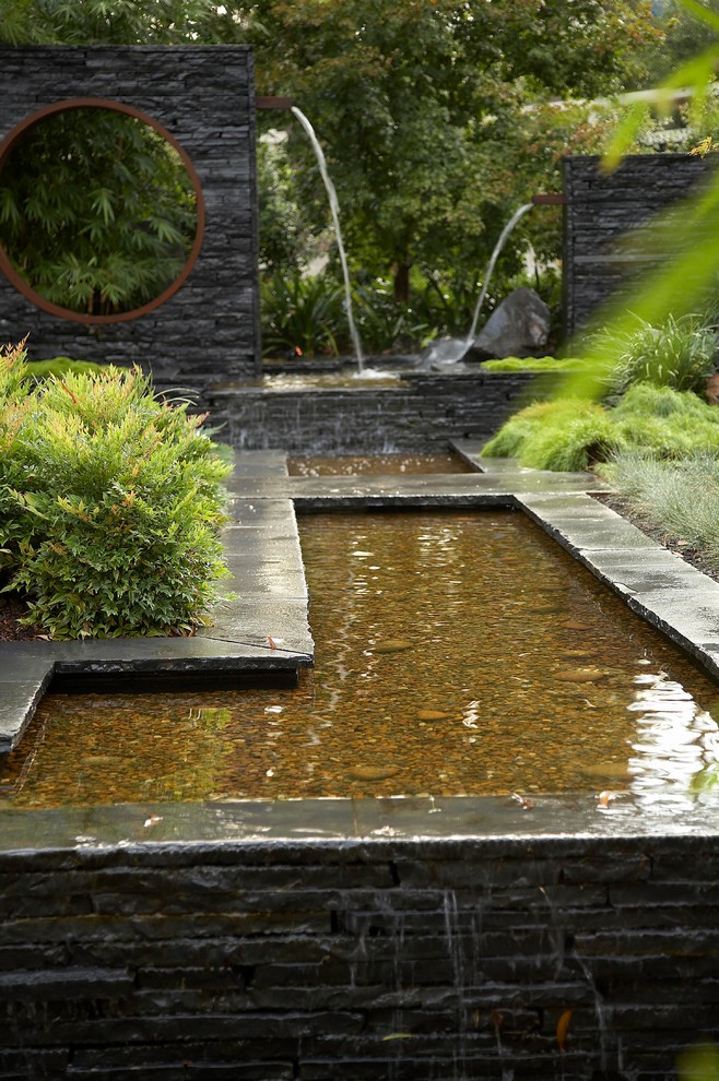 Foto på en orientalisk trädgård, med en fontän
