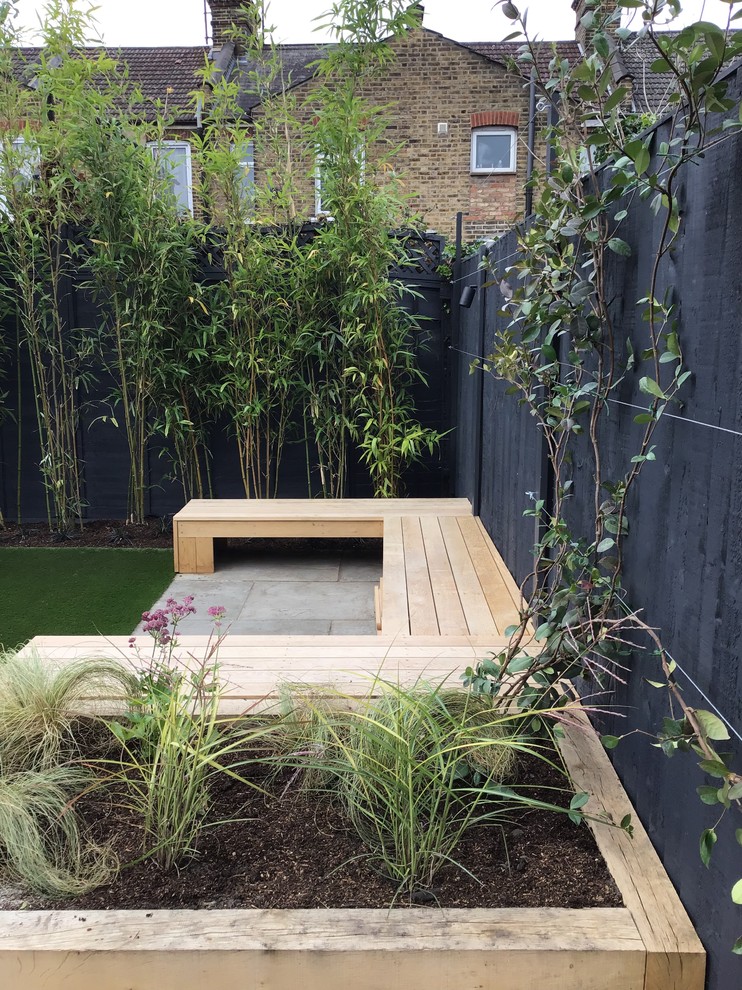 Mittelgroßer, Halbschattiger Moderner Garten im Sommer, hinter dem Haus mit Hochbeet und Natursteinplatten in London
