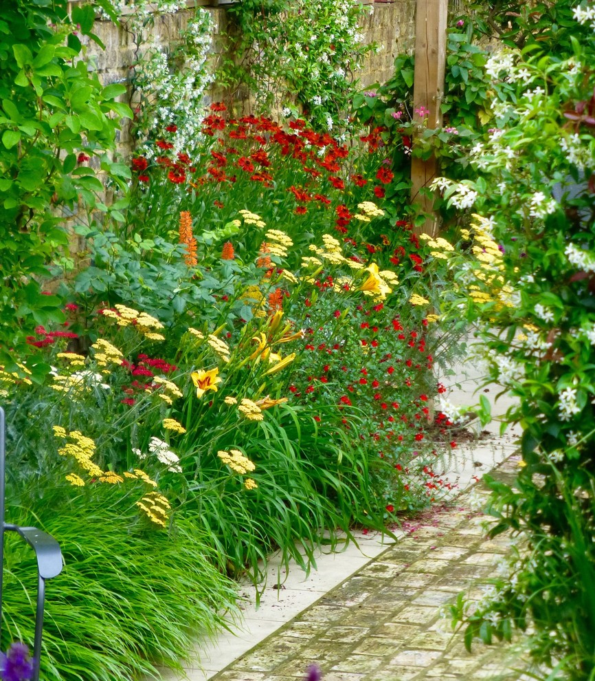 Mittelgroßer Klassischer Garten im Sommer, hinter dem Haus mit direkter Sonneneinstrahlung und Natursteinplatten in London