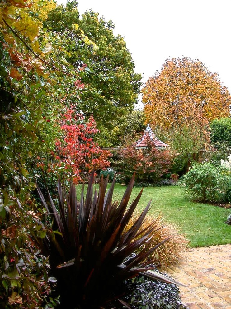 Idee per un giardino classico esposto in pieno sole di medie dimensioni e dietro casa in autunno con pavimentazioni in mattoni