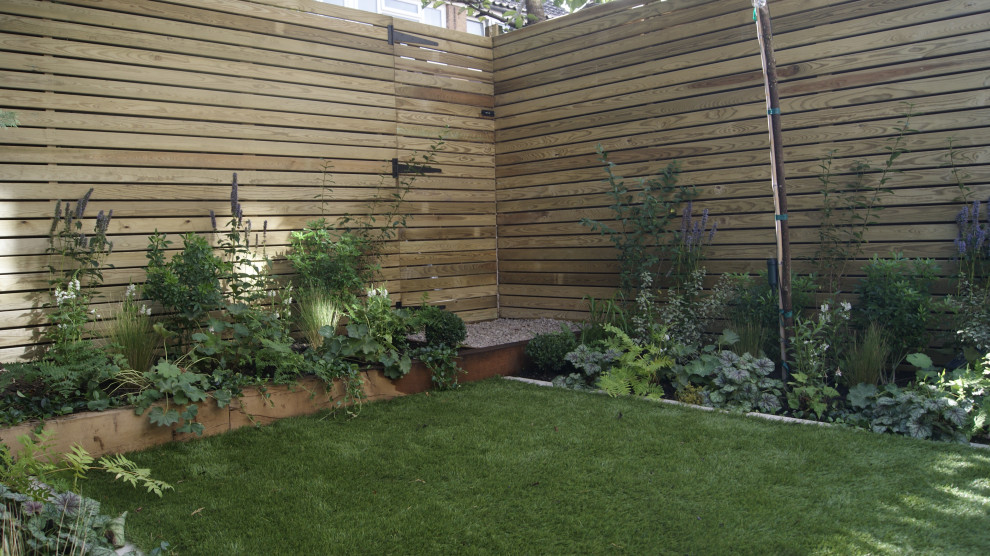 Idee per una piccola aiuola moderna esposta a mezz'ombra dietro casa con pavimentazioni in pietra naturale
