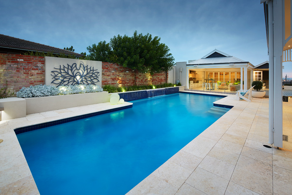Modelo de piscina con fuente contemporánea grande en patio trasero con adoquines de piedra natural