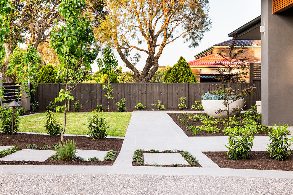 This is an example of a mid-sized traditional partial sun front yard stone landscaping in Melbourne.