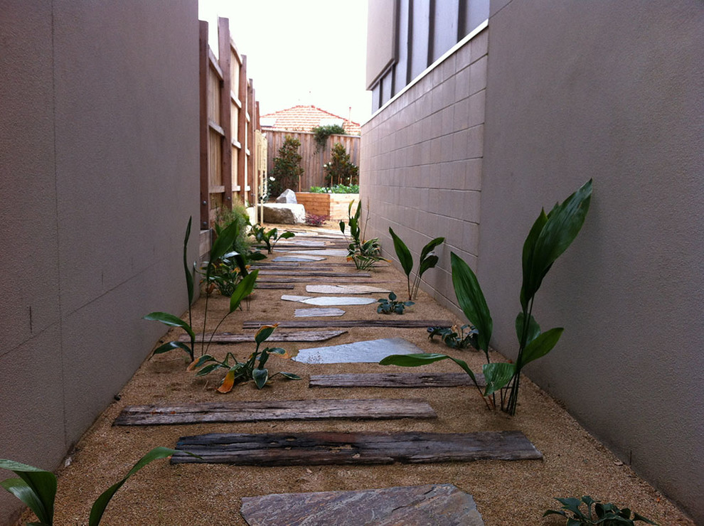 Cette image montre un aménagement d'entrée ou allée de jardin latéral design de taille moyenne et l'automne avec une exposition partiellement ombragée et des pavés en pierre naturelle.