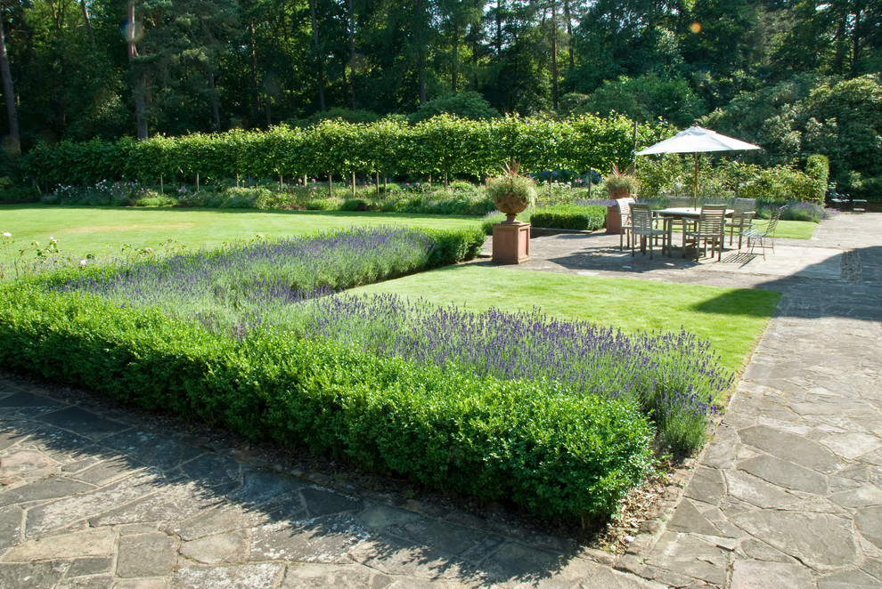 Foto di un grande giardino formale american style esposto in pieno sole dietro casa in estate con pavimentazioni in pietra naturale