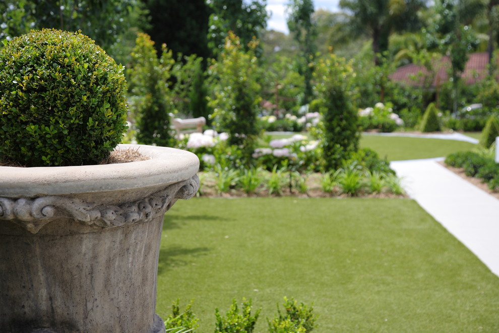 Ispirazione per un giardino formale design esposto in pieno sole di medie dimensioni e davanti casa con un giardino in vaso e pavimentazioni in pietra naturale