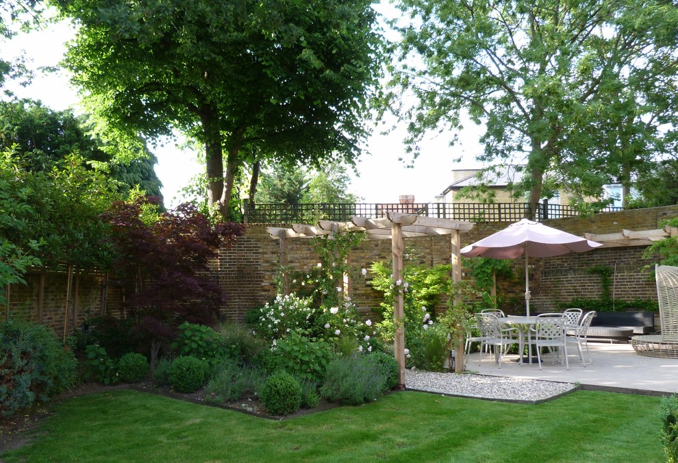 Imagen de jardín de estilo americano grande en verano en patio con jardín francés, exposición parcial al sol y adoquines de piedra natural