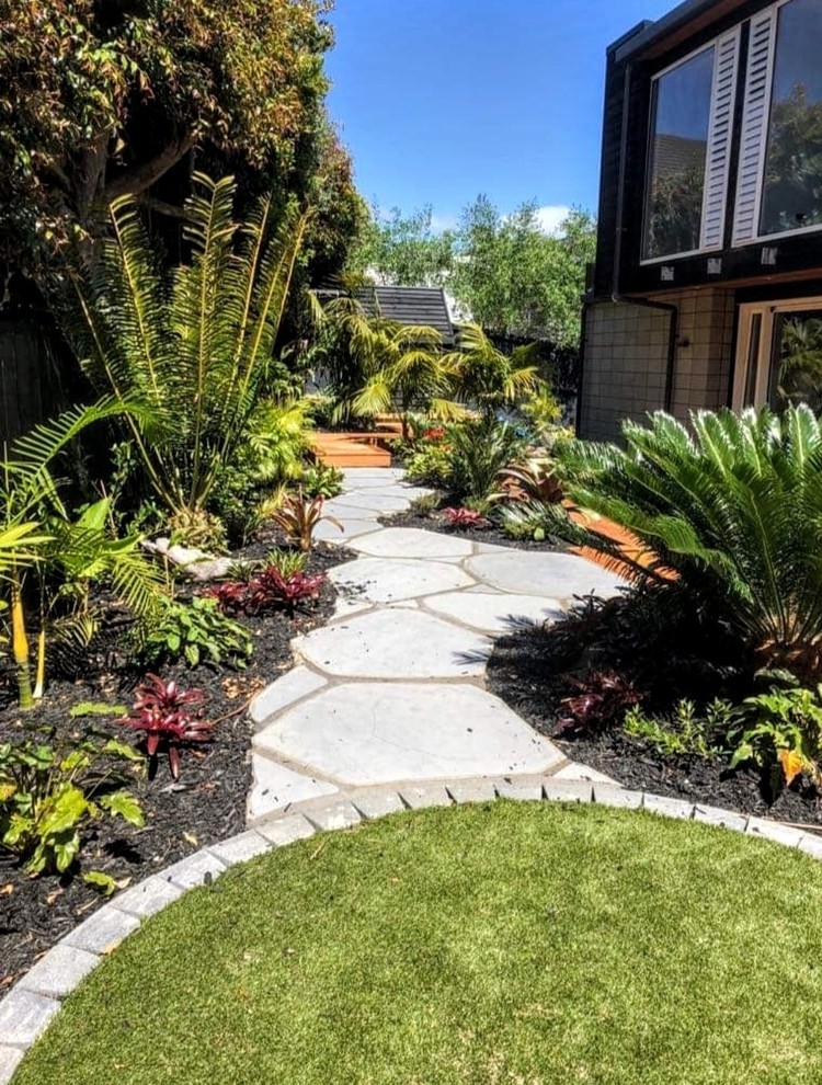Inspiration for a small world-inspired back full sun garden for spring in Auckland with a garden path and decking.