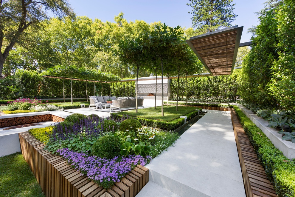 Idée de décoration pour un jardin à la française design avec des pavés en béton.