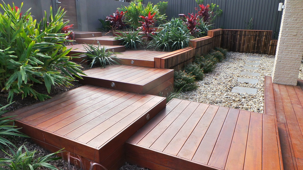 Inspiration pour un aménagement d'entrée ou allée de jardin avant minimaliste de taille moyenne avec une exposition ensoleillée et une terrasse en bois.
