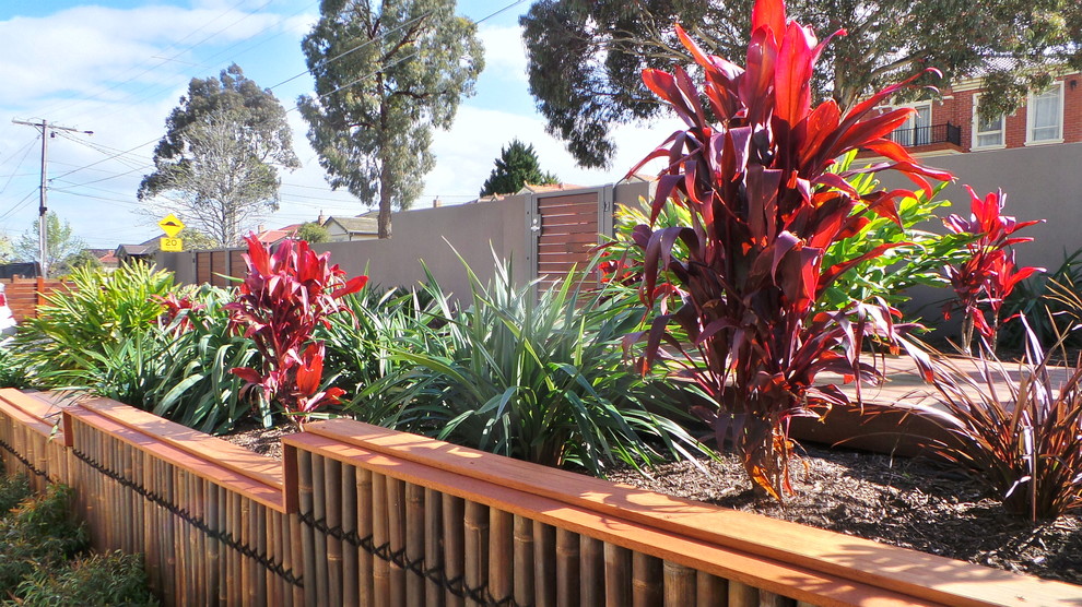 Imagen de jardín moderno de tamaño medio en patio delantero con muro de contención, exposición total al sol y entablado