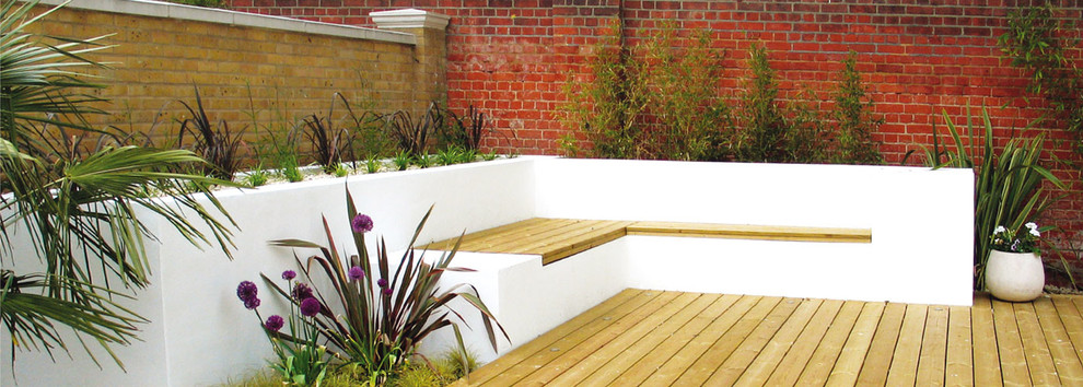 Design ideas for a mid-sized contemporary full sun backyard landscaping in London with decking for summer.