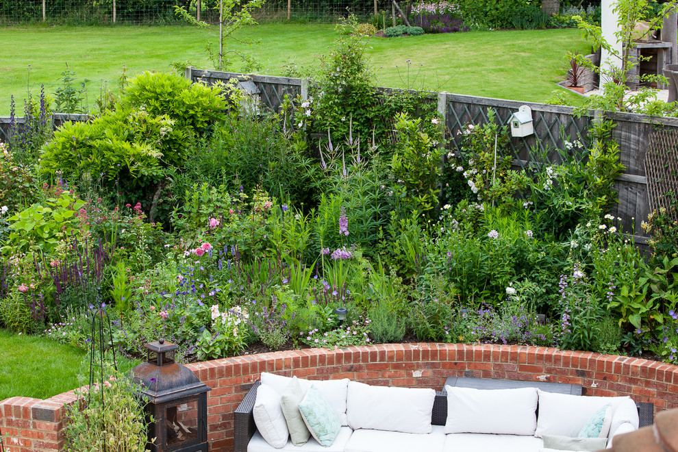 Idée de décoration pour un jardin arrière champêtre de taille moyenne et l'été avec une exposition ensoleillée et des pavés en brique.