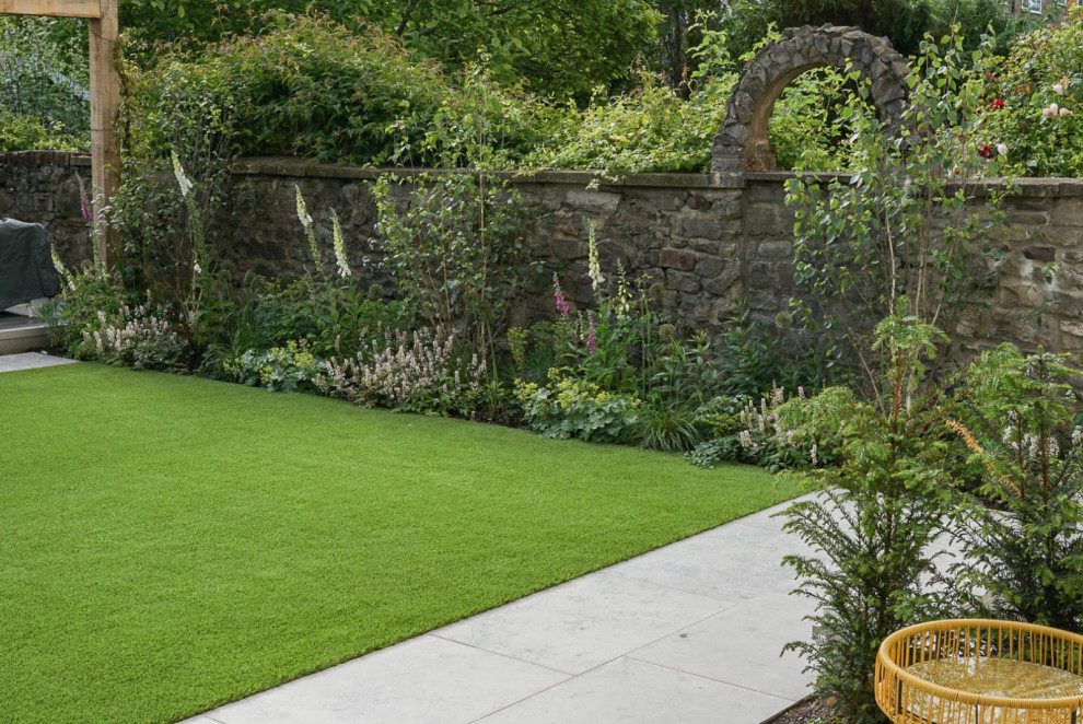 Foto de jardín contemporáneo de tamaño medio en verano en patio trasero con jardín francés, borde del césped, exposición parcial al sol y adoquines de piedra natural
