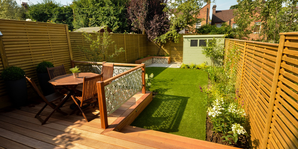 Imagen de jardín moderno de tamaño medio en verano en patio trasero con exposición parcial al sol y entablado