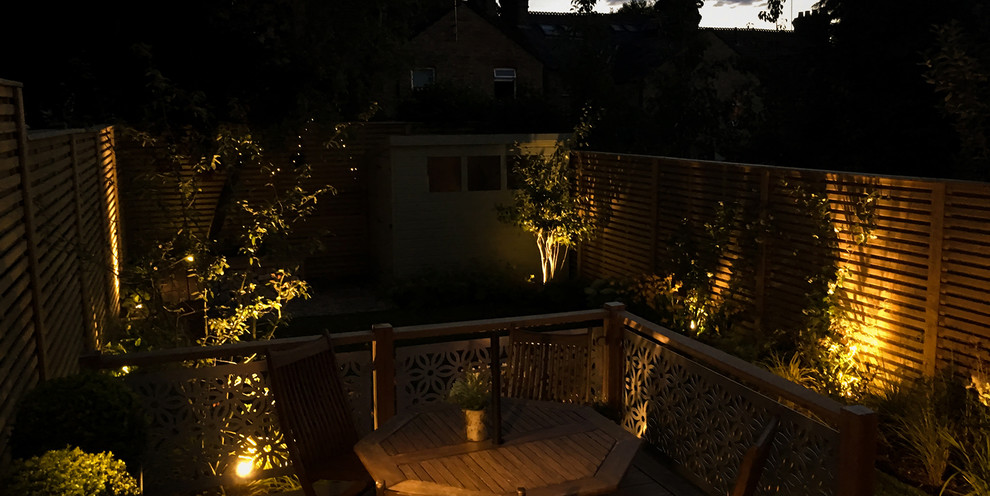 Imagen de jardín minimalista de tamaño medio en verano en patio trasero con exposición parcial al sol y entablado