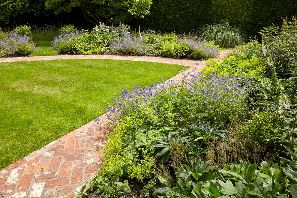 Inspiration for a medium sized rural front formal partial sun garden for spring in Wiltshire with a garden path and brick paving.