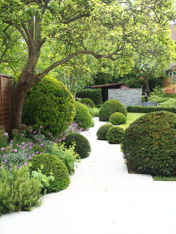 Aménagement d'un jardin à la française arrière classique au printemps avec une exposition partiellement ombragée.