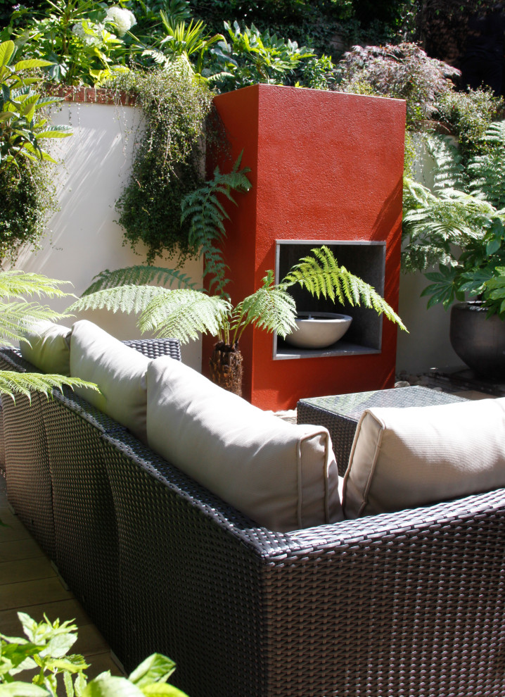 Ispirazione per un piccolo giardino formale minimalista esposto a mezz'ombra dietro casa con un caminetto e pedane