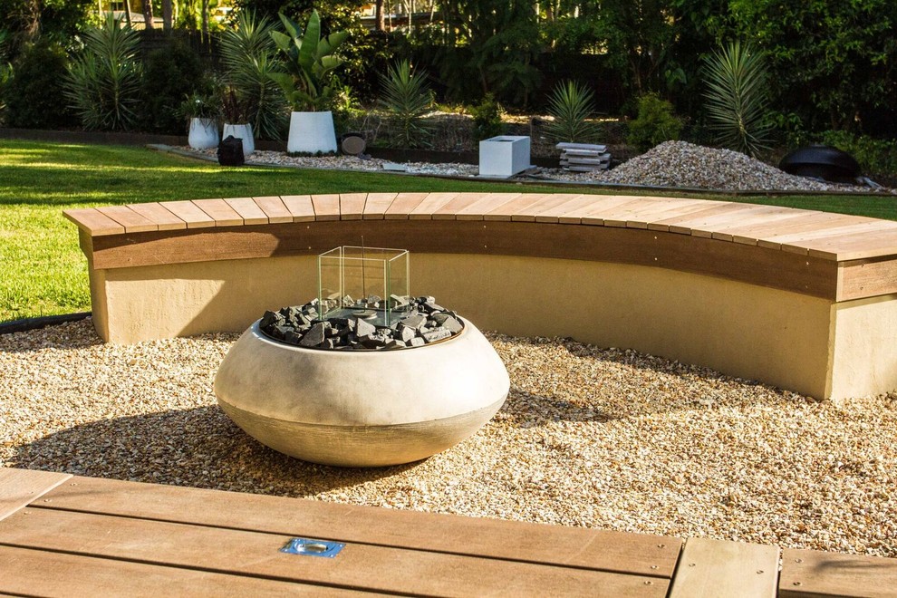 На фото: регулярный сад на заднем дворе в современном стиле с местом для костра, полуденной тенью и покрытием из гравия с