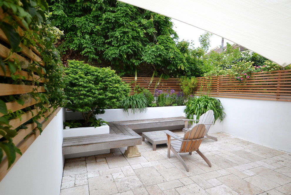 Imagen de jardín contemporáneo de tamaño medio en verano en patio trasero con exposición total al sol y adoquines de piedra natural