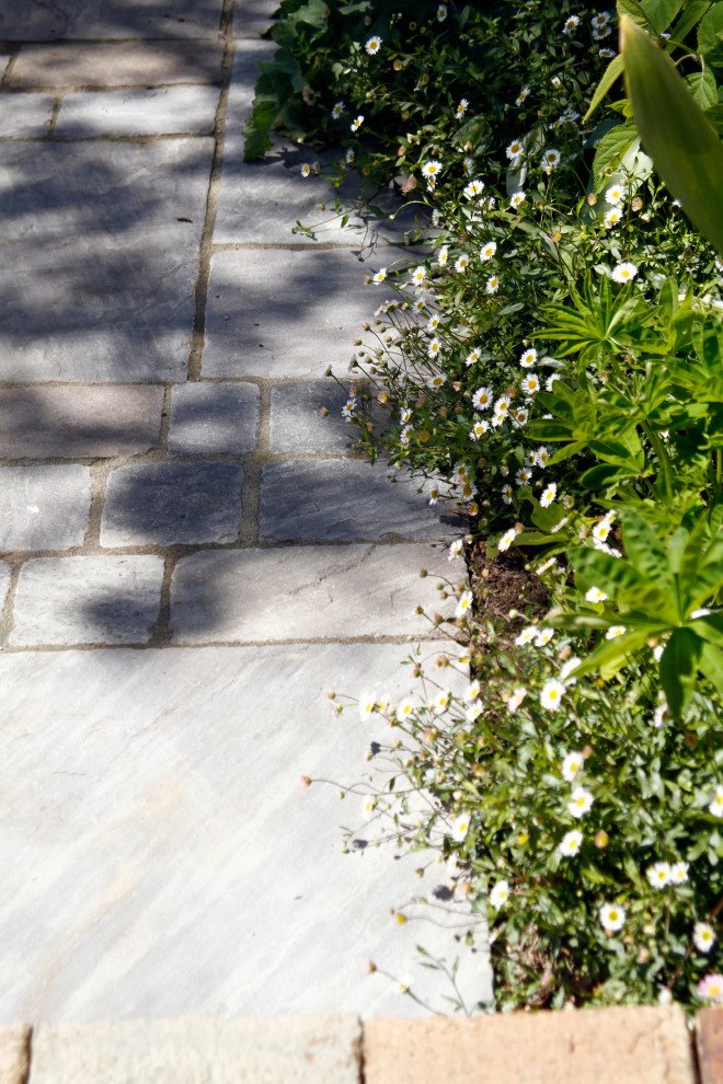 Cette image montre un petit jardin à la française arrière bohème l'été avec une cheminée, une exposition partiellement ombragée et des pavés en pierre naturelle.