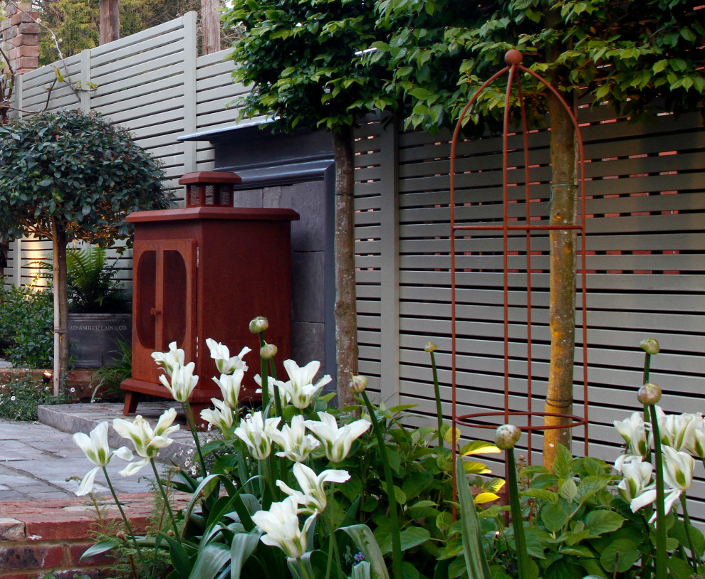 Esempio di un piccolo giardino formale boho chic esposto a mezz'ombra dietro casa in estate con un caminetto e pavimentazioni in pietra naturale
