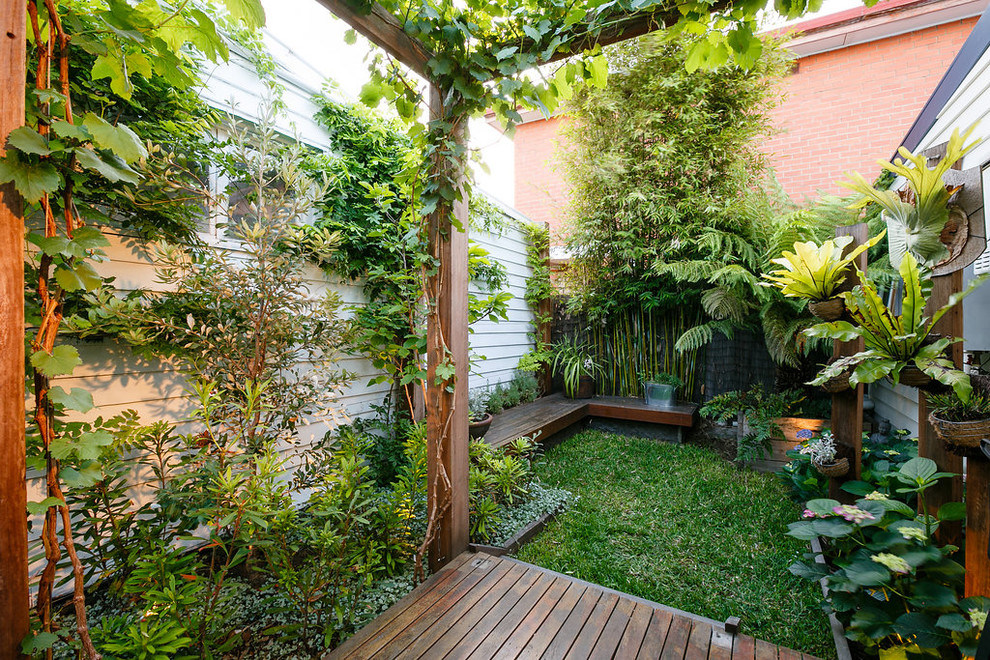 Пример оригинального дизайна: маленький регулярный сад на заднем дворе в морском стиле с настилом и подпорной стенкой для на участке и в саду