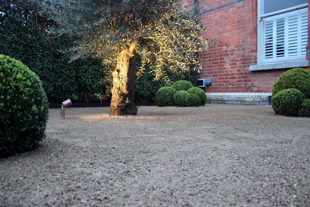 Immagine di un piccolo giardino formale vittoriano esposto in pieno sole davanti casa in estate con un ingresso o sentiero e pavimentazioni in pietra naturale