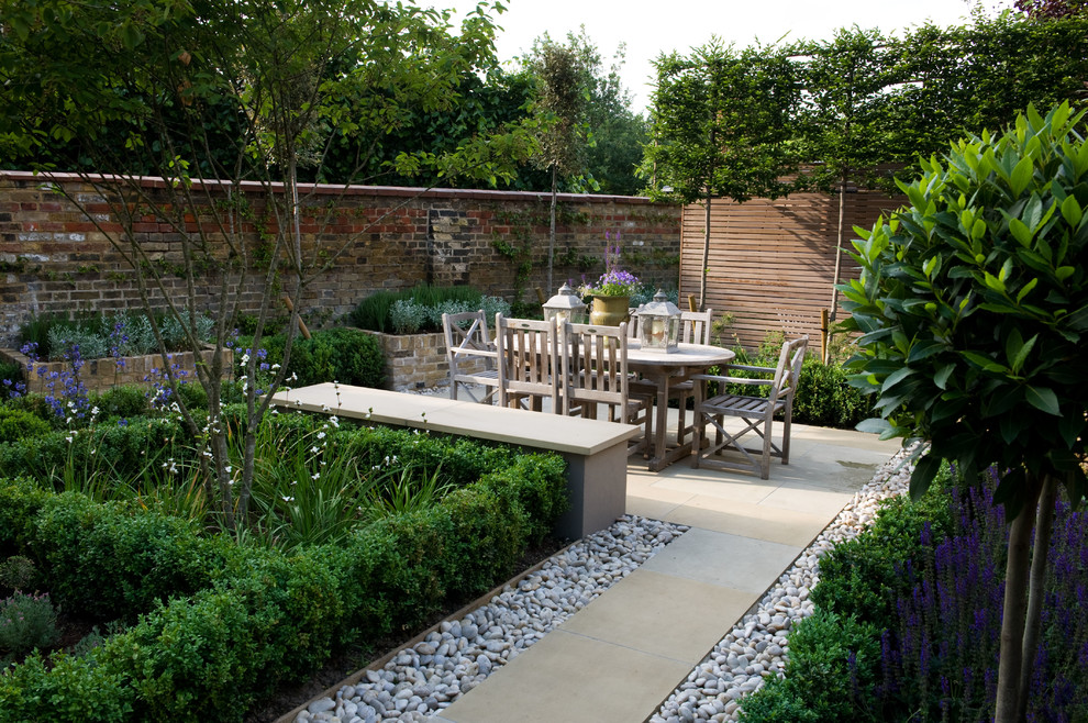 Imagen de jardín bohemio pequeño en patio trasero con jardín francés, fuente y adoquines de piedra natural