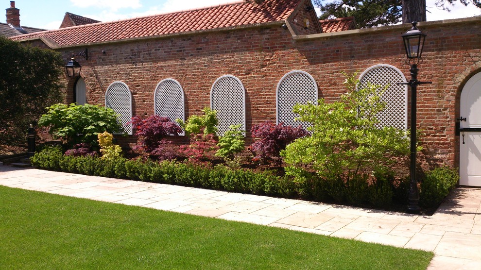 Ispirazione per un giardino formale chic esposto a mezz'ombra di medie dimensioni in autunno con pavimentazioni in pietra naturale