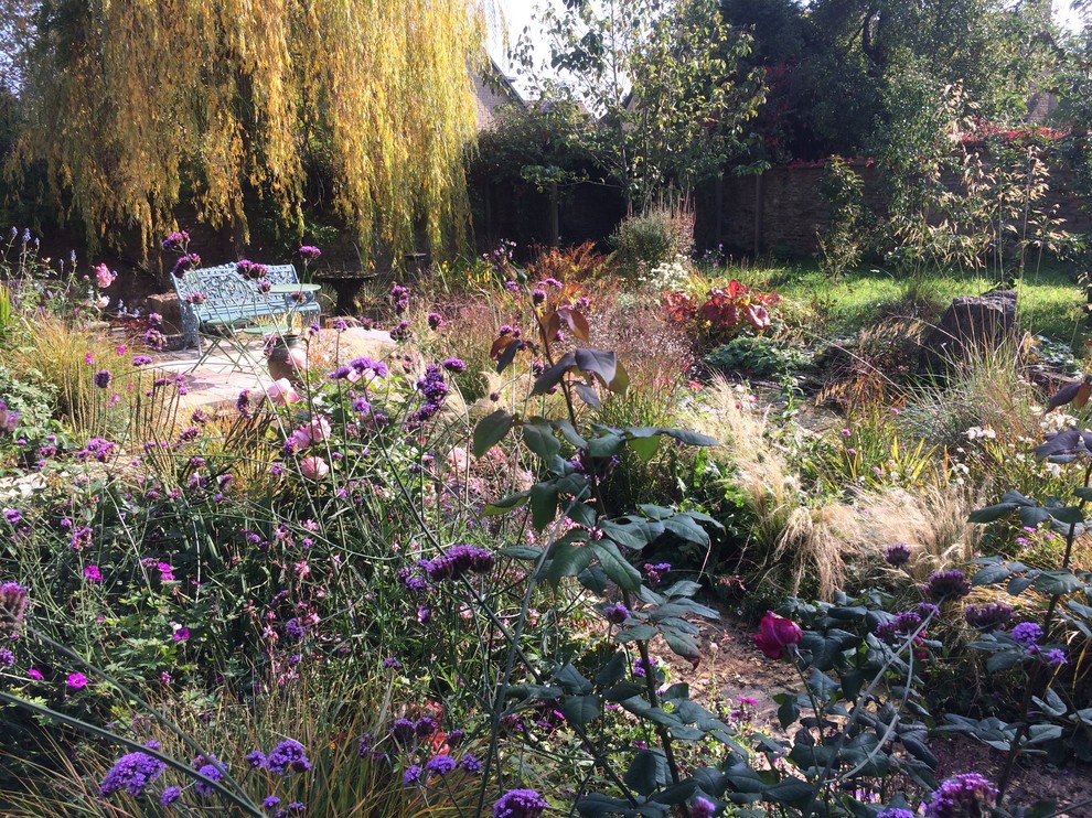 Modelo de jardín clásico renovado en patio trasero con estanque, exposición total al sol y adoquines de piedra natural