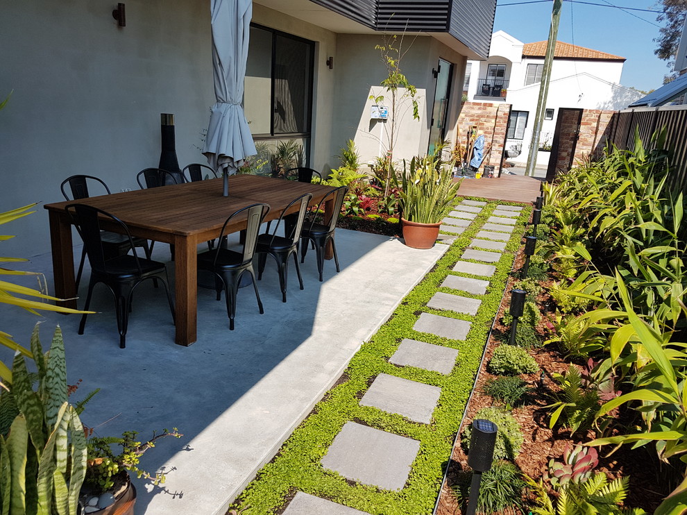 This is an example of a small world-inspired sloped formal partial sun garden in Perth with a garden path and natural stone paving.