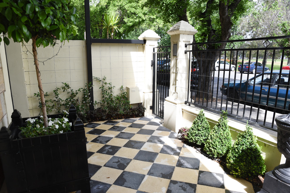 Immagine di un piccolo giardino formale tradizionale esposto a mezz'ombra in cortile con pavimentazioni in cemento